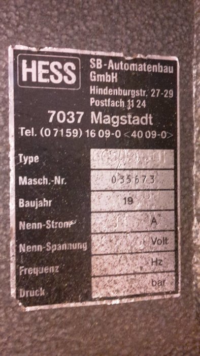 Skylt på en maskin med teknisk information från HESS SB-Automatenbau, inklusive telefonnummer och specifikationer om maskintyp och nummer.