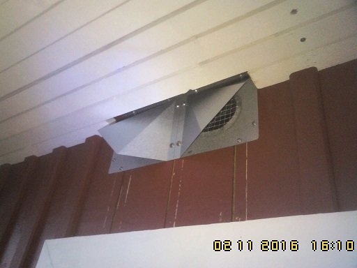EOS-ventil monterad nära yttervägg med vita takplankor och bruna väggplattor.