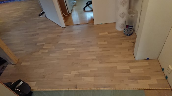 Nyinstallerat laminatgolv i ett rum redo för återplacering av kamin.