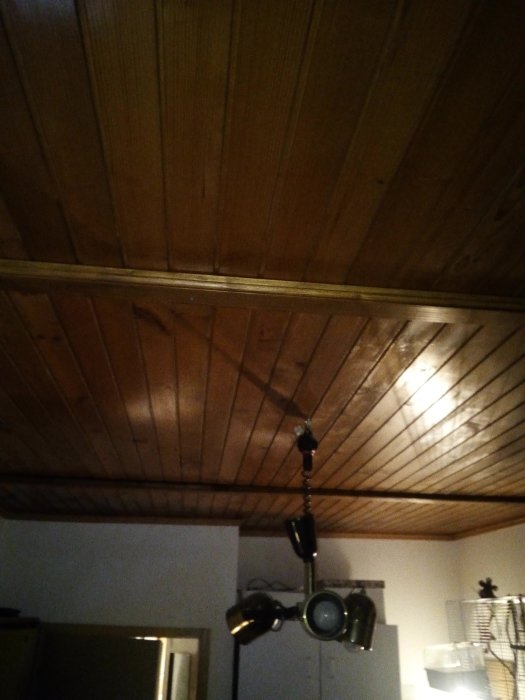 Två vågräta plankor längs med ett träbeklätt tak, möjliga skarvar eller kabelföring dolda.