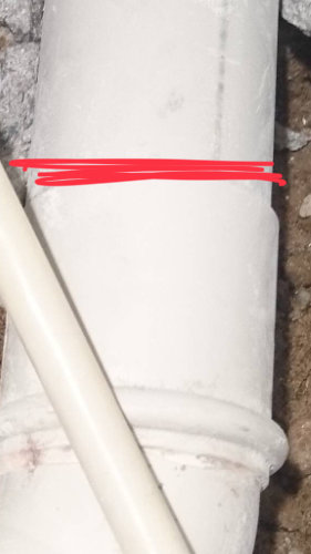 Avloppsrör med markerat rött streck för kapning efter skarv, närbild.