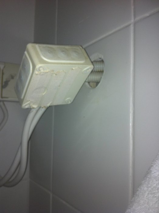Oanvända kablar anslutna till en genomföringsplint på väggen, föreslår demontage för renovering.