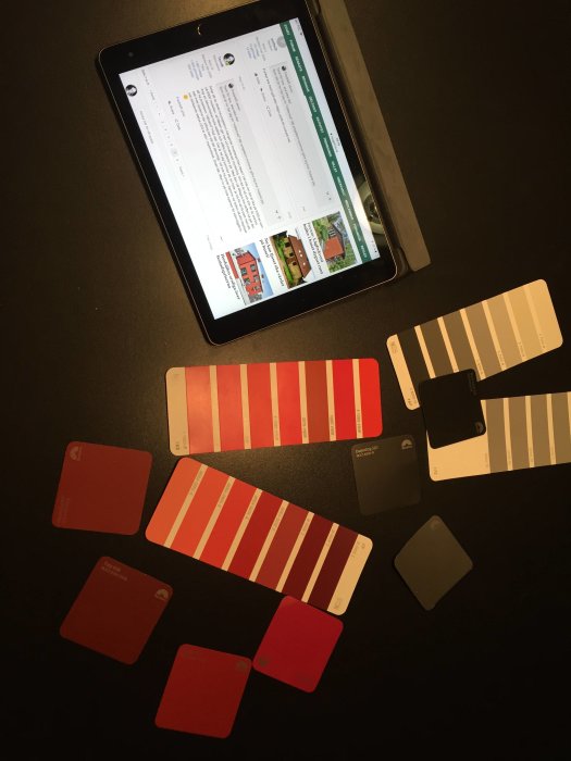 En surfplatta som visar ett forum inlägg med runt spridda färgprover i olika nyanser av rött och grått.