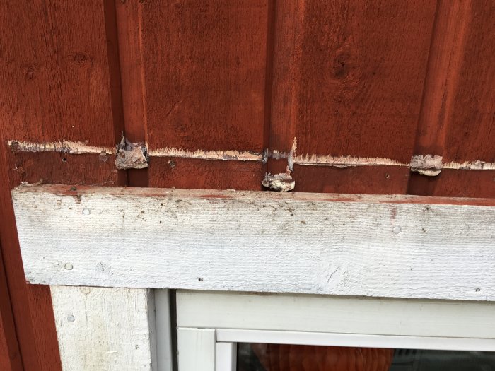 Bild på fasad där felaktig plåt tagits bort, visar vattenskador och exponerad originalpanel.