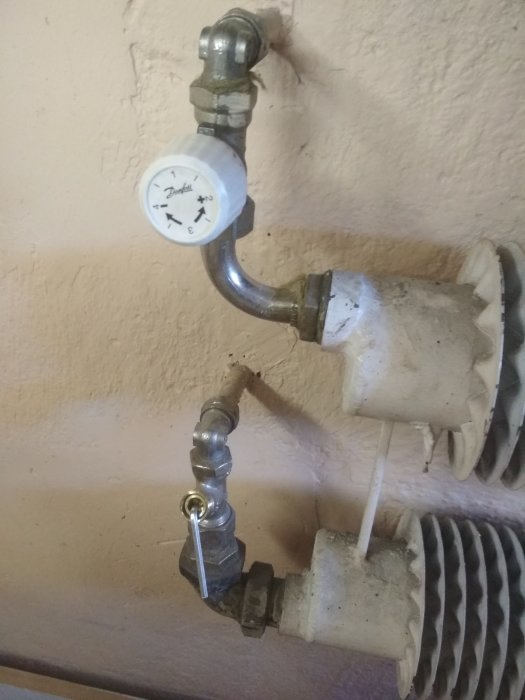 Element i garage med synlig termostat och anslutningsrör som inte blir varmt.