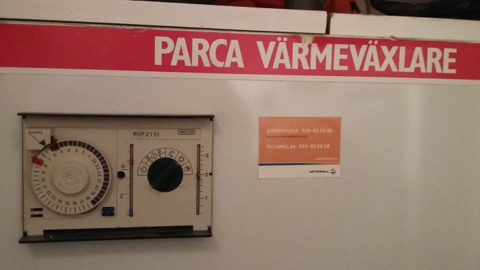 Värmeregulatorpanel märkt "PARCA VÄRMEVÄXLARE" med inställningsrattar, dygnsur och kundservicekort från Vattenfall.