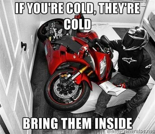Motorcykel parkerad inomhus med en person i MC-utrustning som sitter på den, med texten "If you're cold, they're cold, bring them inside".