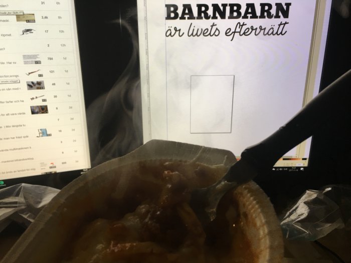 Person som äter lasagne framför en datorskärm med texten "Barnbarn är livets efterrätt".