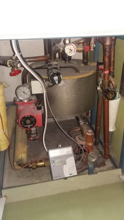 Värmesystem med shunt, cirkulationspump, manometer och rör i ett pannrum.