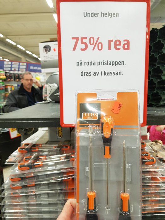 Hand håller ett Bahco skruvmejselset framför en reaskylt som annonserar 75% rea på Jula Kungens Kurva.