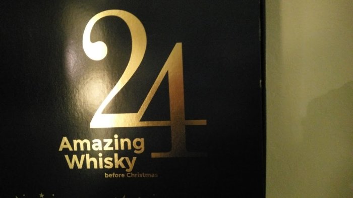 En bild på en svart låda med gyllene siffror "24" och texten "Amazing Whisky before Christmas".