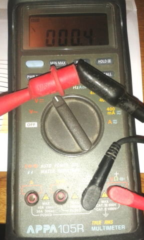 Multimeter med ihoplagda ledare som visar 0,4 ohm på displayen.