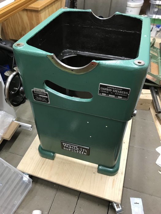 Delvis ihopsatt grön Wadkin Bursgreen sågmaskin med synliga märken och tillbehör på ett verkstadsbord.