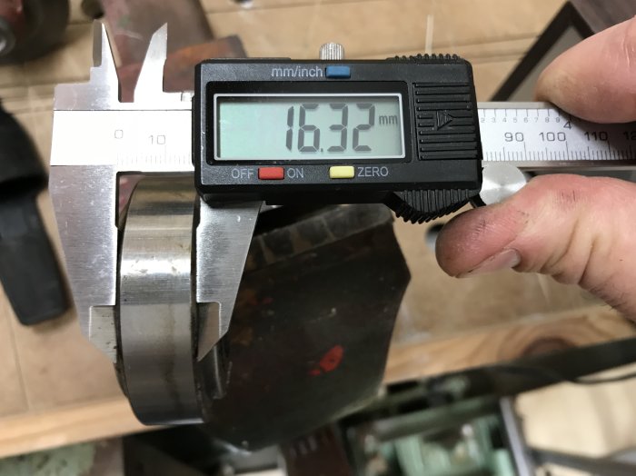 Skjutmått som mäter diameter på metallföremål, visar 16.32 mm på digital display.