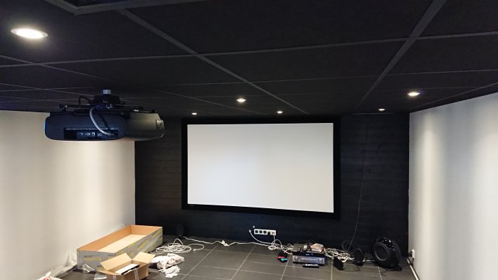 Hemmabio med 12 inbyggda spotlights i taket, projektorduk och projektor monterad i taket.