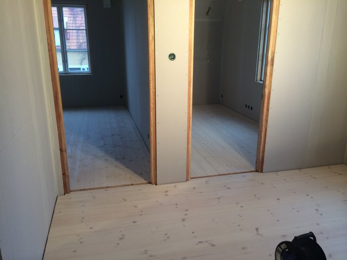 Nyinstallerat lutat och vitoljat furugolv i en övervåning under renovering.