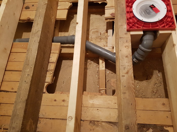 Golvbjälklag med rörinstallationer och en röd ventilationshatt utan håltagning.