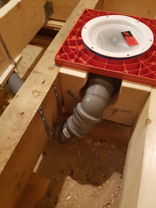 Avloppsrör i golvkonstruktion med synlig installation av en toalettfläns.
