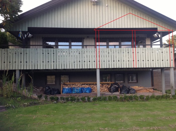 Ett hus med pågående renovering av ett uterum på en befintlig altan upphöjd på pelare, markerat med ett rött streck.