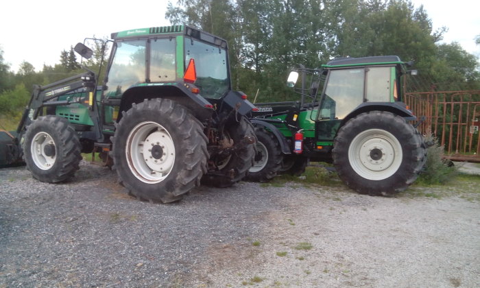 Två gröna traktorer, Valmet och Valtra, parkerade bredvid varandra utomhus.