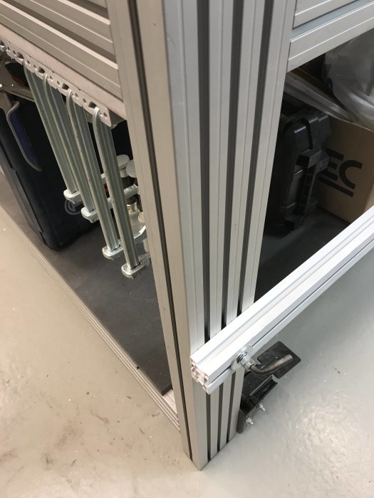 Höj- och sänkbart hjul monterat på ett metallben på verkstadsutrustning, i nedfällt stadigt läge.