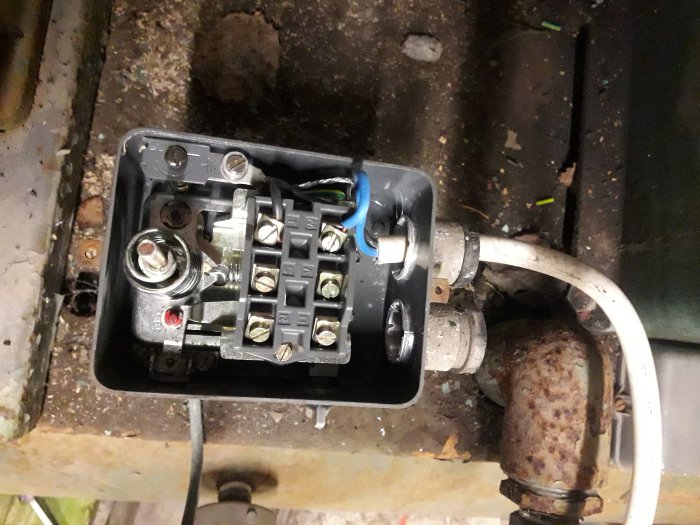 Öppet elektriskt kopplingsskåp med trådar och anslutningar, några avklippta, indikerar reparation eller fel sökning.