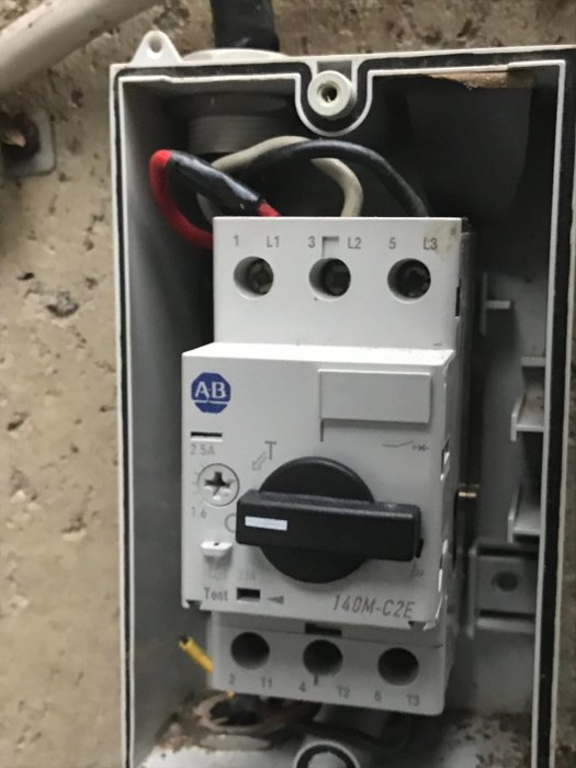Motorbrytare av märket AB med inställningar och ledningar i en elektrisk installationsdosa.