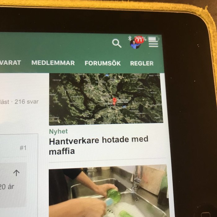 iPad som visar ett diskussionsforum med en karta överlägsen texten "Hantverkare hotade med maffia".