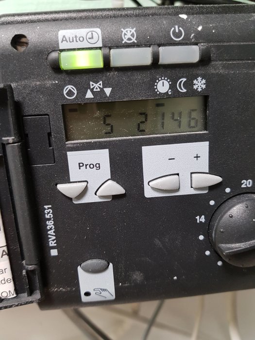 Närbild av en elektronisk termostat med display och inställningsknappar.