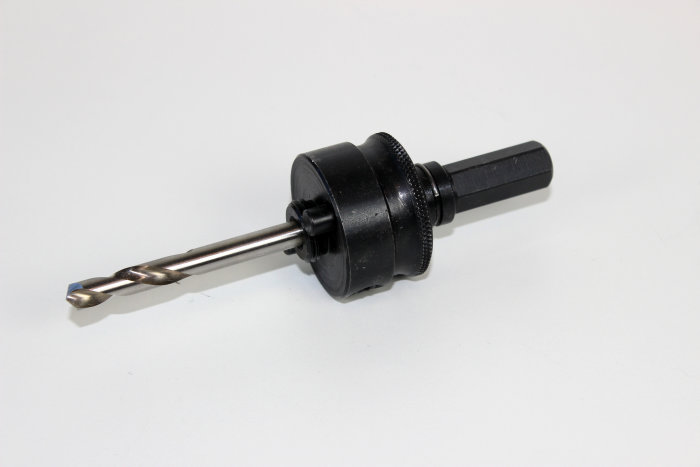 Hållare för hålsåg med monterad borrbit på vit bakgrund.