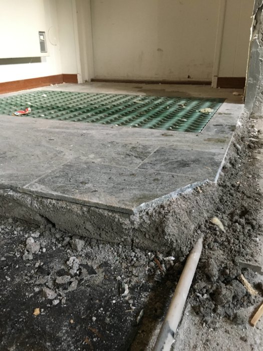 Renoveringsprojekt visar uppbruten betong och ett grönt upphöjt golvsystem.
