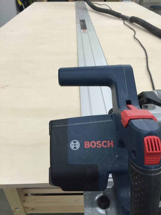 Bosch sticksåg redo att skära i plywood på arbetsbänk för garderobsbygge.