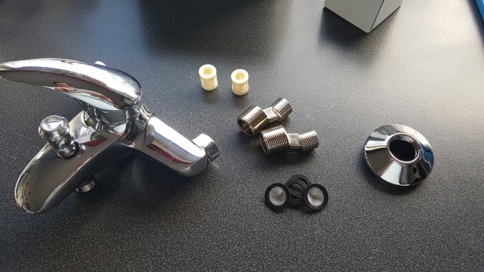 Kromad blandare med excenterkopplingar och packningar på en bänkskiva.