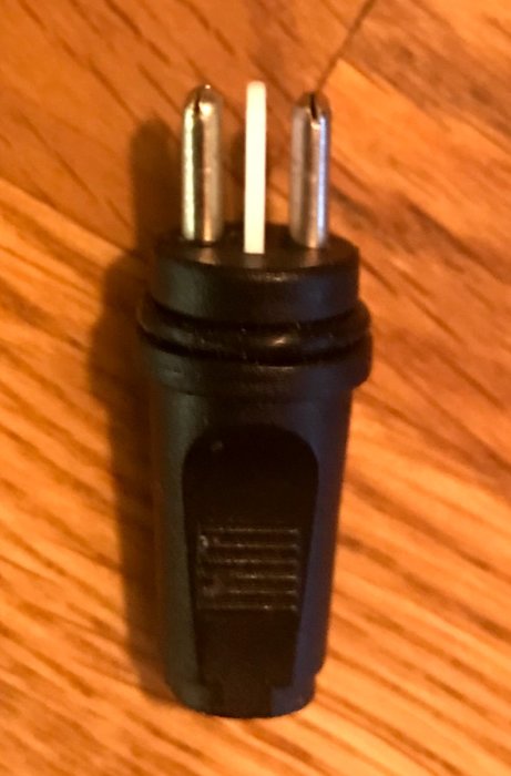 Närbild av en trefas elkontakt med en fråga om dess namn och skarvsladd.