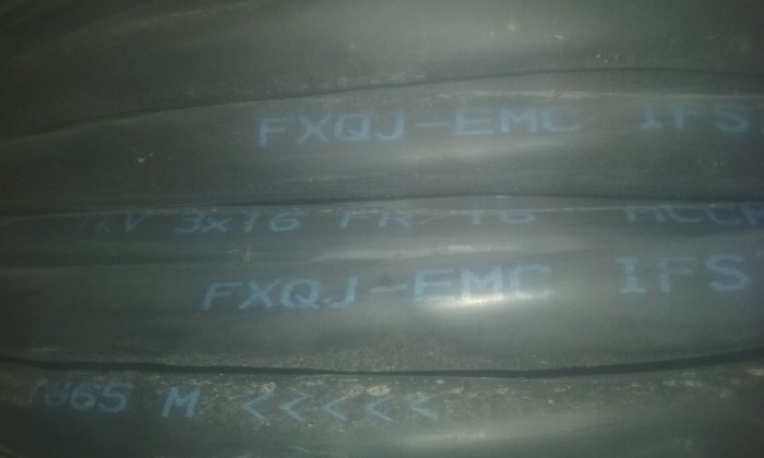 Svart kabel markerad med "FXQJ-EMC 1kV 3x16 FR/16" för elinstallationer, i svagt ljus.