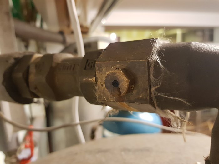 Ventil med okänd funktion, täckt av damm och spindelnät, misstänkt läckande säkerhetsventil.