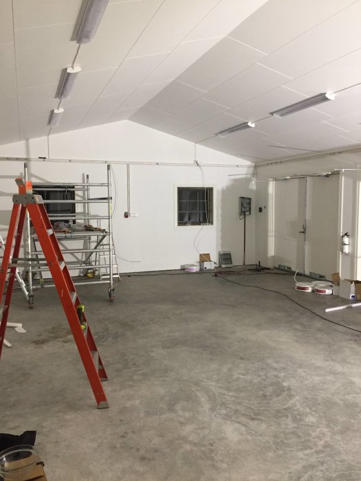 Ett under renovering garage med synliga elektriska skenor och arbetsställning.