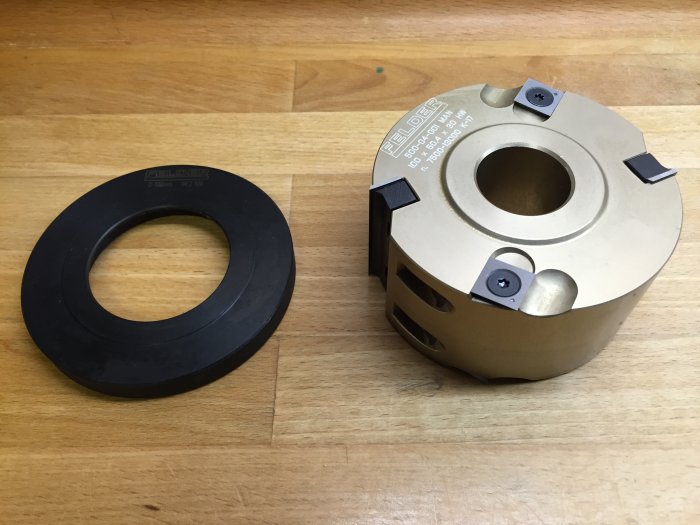 En falskutter och en svart mallring på ett trägolv.