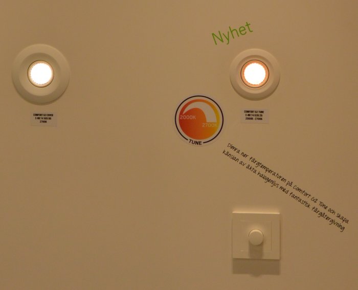 Två spotlights på vägg med märkningen "Comfort G2 Tune", en tänd i varmare ljus, och en informationsetikett.