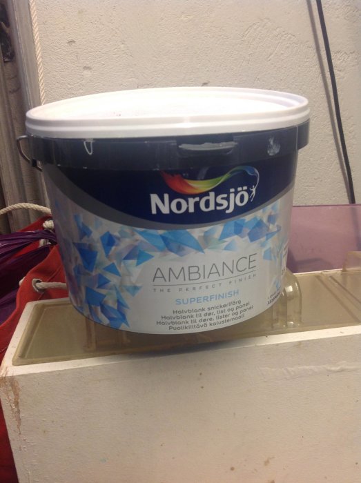 En burk Nordsjö Ambiance Superfinish lackfärg på en hylla, använd för invändigt snickeri.