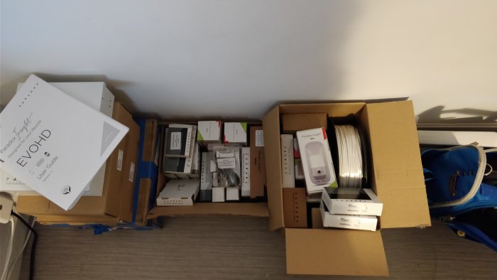 Oanvända Paradox larmkomponenter i originalförpackningar på ett golv.