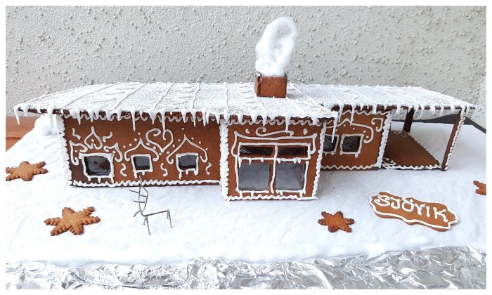 Pepparkakshus med dekorationer som föreställer ett ritat drömhus på en udde.