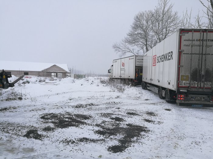 Två lastbilar på en snöig och blöt byggarbetsplats, verkar svårt att köra.