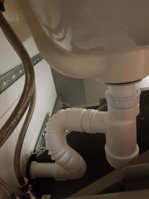 Nyinstallation av vattenlås med 40mm styvt rör och flexibelt rör under handfatet.