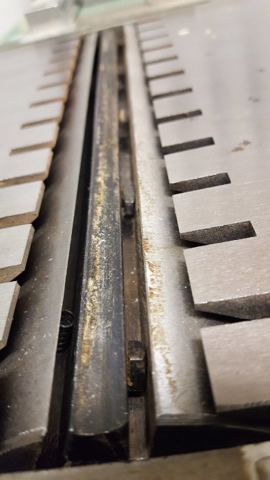 Närbild på knivar i en hyvelmaskin med 250 mm breda stål och synliga fjädrar.