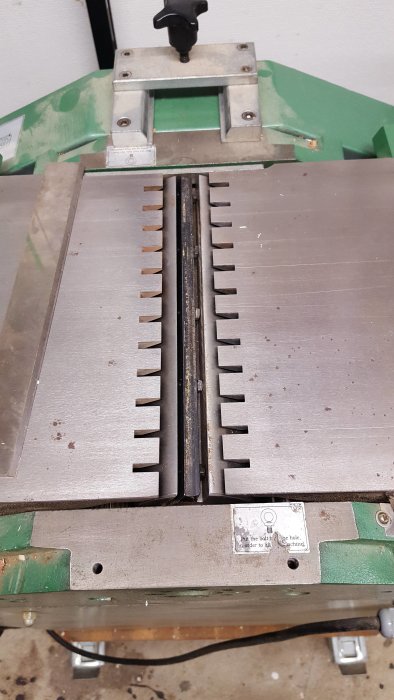 Närbild på en hyvelmaskin med synliga 250 mm breda hyvelstål i en kutter.