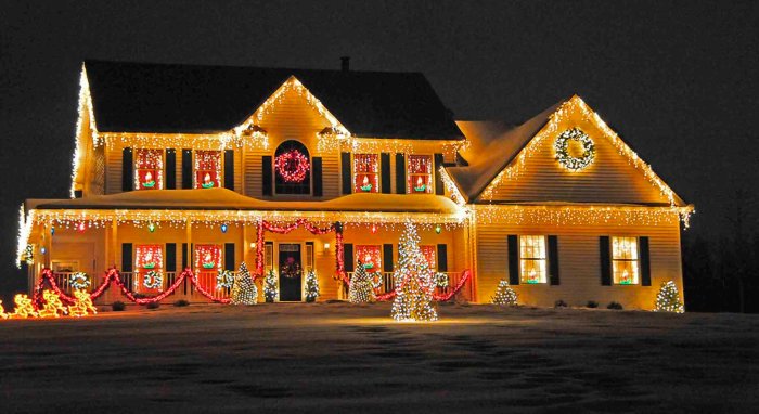 Ett hus dekorerat med julbelysning inklusive ljusslingor, kransar och ljusfigurer.