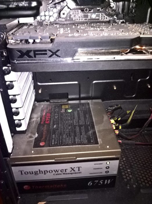 Interiör av en dator med XFX grafikkort och en Thermaltake Toughpower XT 675W nätaggregat.