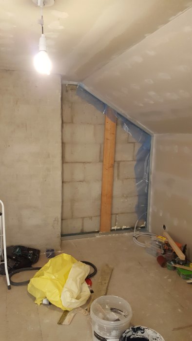 Renoveringsarbete på ovanvåning med gipsskivor och byggmaterial synliga.