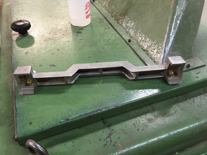 Metalldetalj på grönt maskinbord i en verkstad.